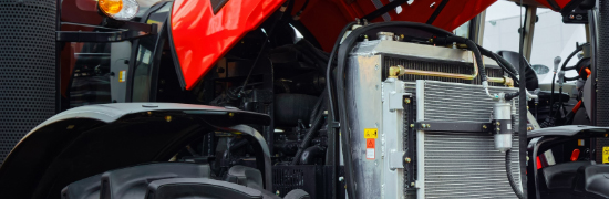 Red tractor hood lifted up exposing the engine